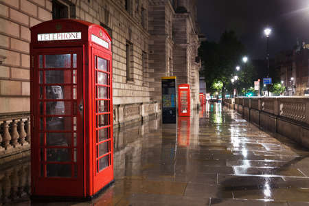 Popular tourist Red phone booth in night lights illumination in London, England, United Kingdomの写真素材