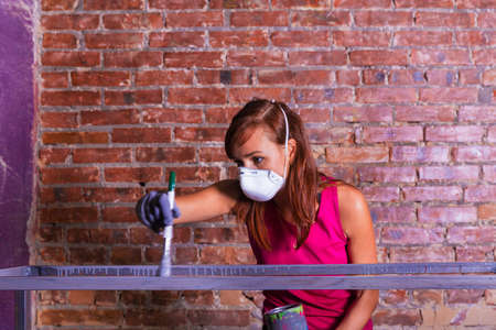 young beautiful woman paints with silver paint brushの写真素材