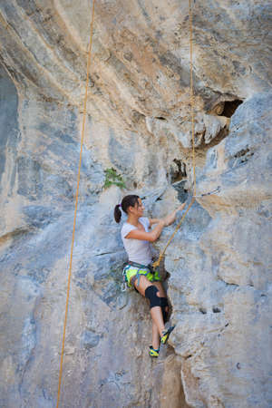 Young woman rock climbing on white mountain  in Thailandの写真素材
