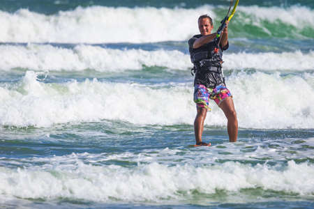 Young athletic man riding kite surf on a sea in Vietnamの写真素材