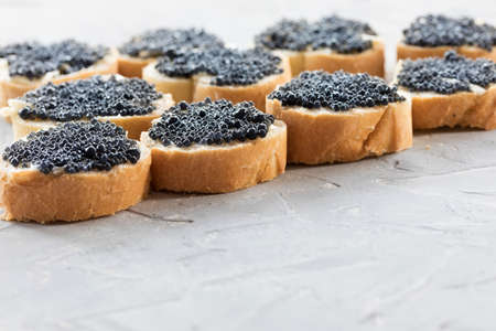 Expensive delicious black caviar white bread sandwich snack on a wooden plateの写真素材