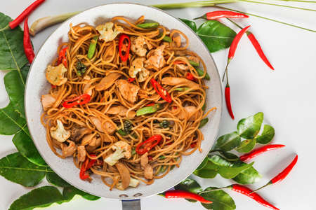 traditional spicy asian cuisine food: wok stir fry spaghetti with fried chicken and thai spices and herbsの写真素材