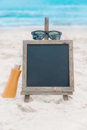 Chalk board with sunscreen cream in the sand on the beach tropic exotic backgroundの写真素材