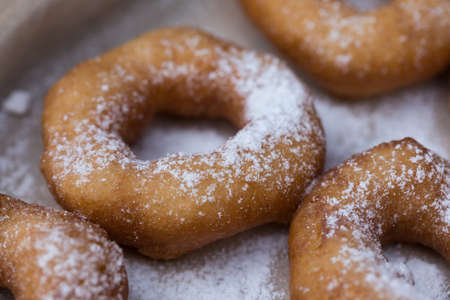 Homemade donuts with icing sugar powder on a wooden backgroundの写真素材