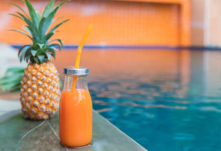 Fresh yellow pineapple tropic fruit summer refreshment smoothie shake drink near poolの写真素材