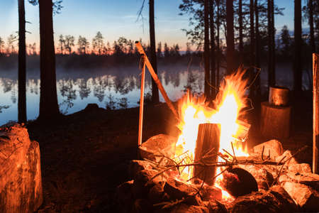 Fireplace in camping near lake at dark night morningの写真素材