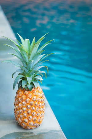 Fresh yellow pineapple tropic fruit summer refreshment near swimming poolの写真素材