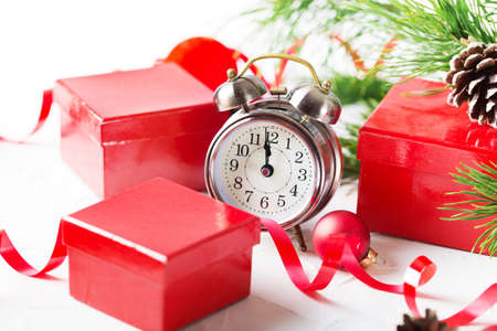 Christmas countdown to the new year. Clock and red balls and fir spruce branches. Holiday composition.の写真素材