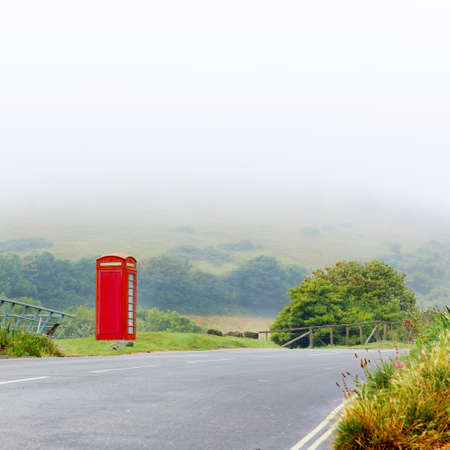 Fog with classical red telephone booth box in misty English countryside, United Kingdomの写真素材