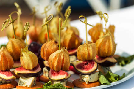 Canapes with physalis, fig, cheese and crackersの写真素材