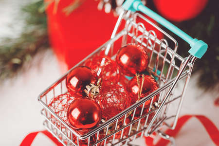 Red Christmas bauble in market basket with branchの写真素材