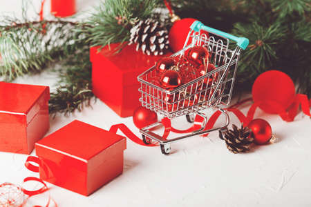 Red Christmas bauble in market basket with branchの写真素材