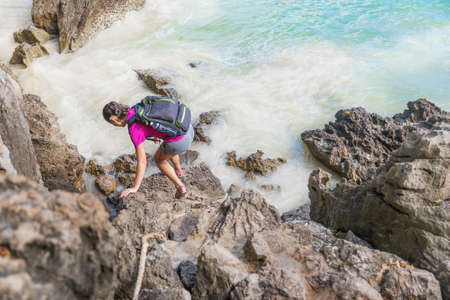 Young woman with hiking bag on a trekking trail in tropical rain forestの写真素材