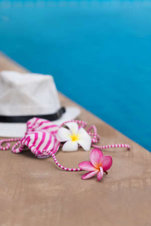 Orchid flower and colorful swimwear near blue swimming poolの写真素材