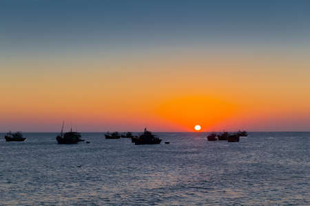 Vietnam Mui Ne village fishing boats and ships in evening sunset light