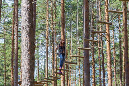 Young brave woman climbing in a adventure rope parkの写真素材