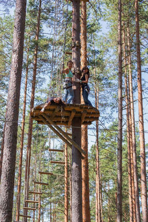 Young brave woman climbing in a adventure rope parkの写真素材