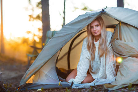 Young blonde woman relax in a camping tentの写真素材