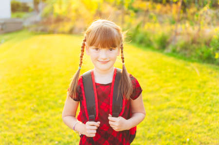 A young little girl preparing to walk to schoolの写真素材