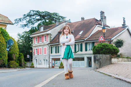 Cute little girl walking on a street in a villageの写真素材