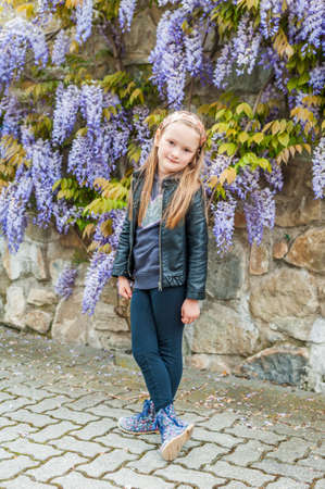 Spring portrait of a cute little girl, wisteria on backgroundの写真素材