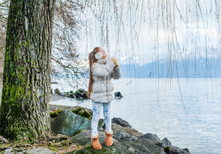 Cute little girl playing outdoors on a nice cold dayの写真素材
