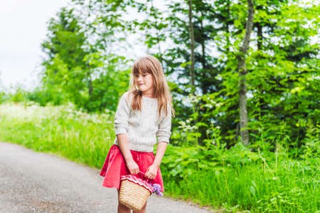 Portrait of a cute little girl with basket with flowersの写真素材