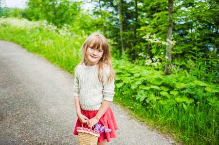Portrait of a cute little girl with basket with flowersの写真素材