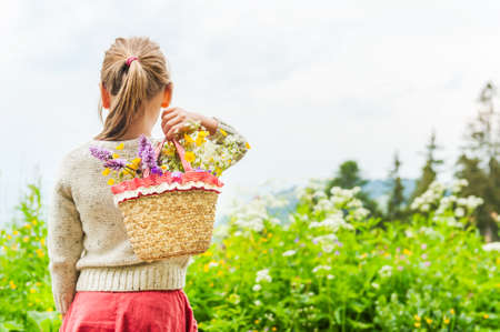 Portrait of a cute little girl with basket with flowersの写真素材