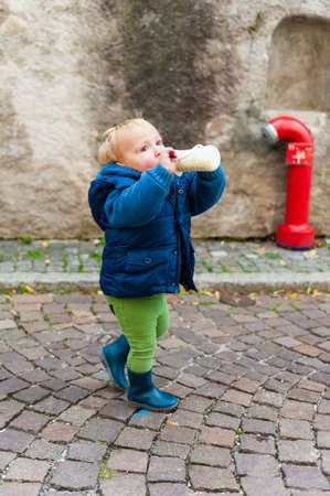 Outdoor portrait of a cute toddler boy with bottle of milkの写真素材