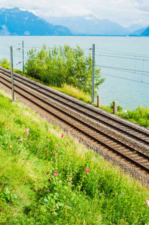 Railway track in Switzerland next to a lake on a nice sunny day