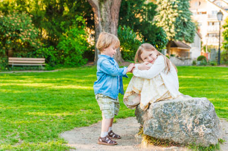 Adorable children playing in a park on a nice sunny  dayの写真素材