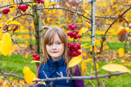 Adorable little girl in autumn gardenの写真素材