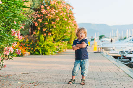 Outdoor portrait of a cute toddler boy on sunsetの写真素材