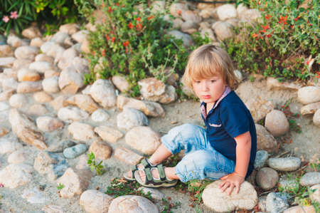Outdoor portrait of a cute toddler boy on sunsetの写真素材