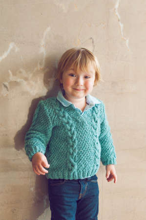 Portrait of a cute toddler boy in a knitted pulloverの写真素材