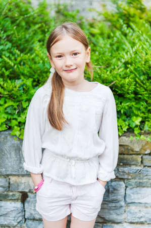 Outdoor, portrait of a cute little girl, wearing white clothesの写真素材