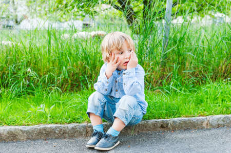 Outdoor portrait of a cute toddler boy on a nice summer dayの写真素材