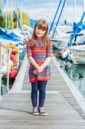 Outdoor portrait of a cute little girl in a port, on a nice sunny spring dayの写真素材