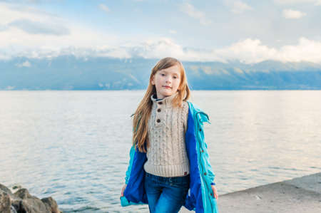 Outdoor portrait of a cute little girl next to lakeの写真素材