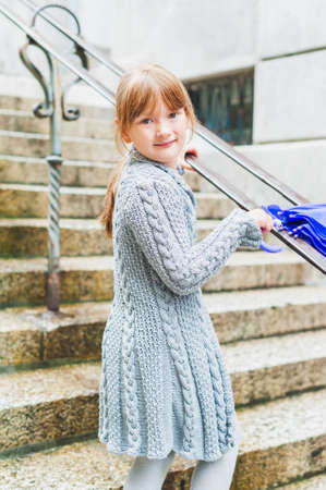 Outdoor portrait of adorable little girl in a city on a rainy dayの写真素材