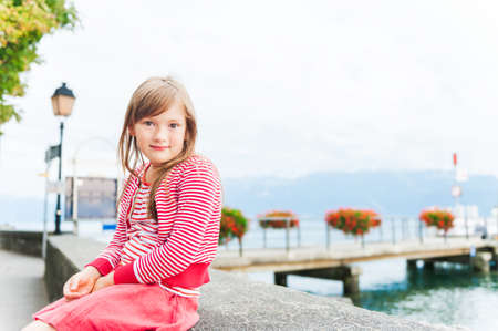 Cute little girl resting next to lakeの写真素材