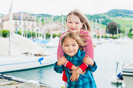 Outdoor portrait of adorable children on a very windy dayの写真素材