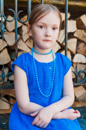 Portrait of a beautiful little girl in a blue dressの写真素材