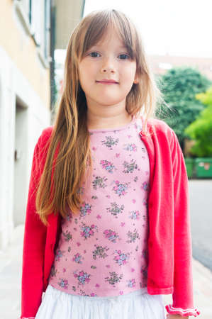Outdoor portrait of beautiful little girl in red jacketの写真素材
