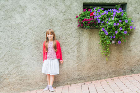 Outdoor portrait of beautiful little girl in red jacketの写真素材