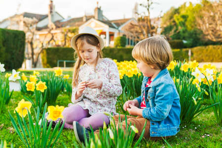 Adorable children playing with flowers on a nice sunny spring dayの写真素材