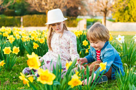 Adorable children playing with flowers on a nice sunny spring dayの写真素材