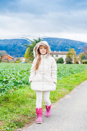 Outdoor portrait of a beautiful little girl on a cold weatherの写真素材