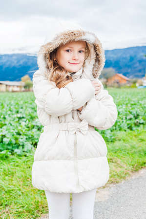 Outdoor portrait of a beautiful little girl on a cold weatherの写真素材